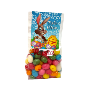 Beutel mit bunten Zuckereiern und Osterhasen-Etikett, liebevoll verpackt mit Osterdekor