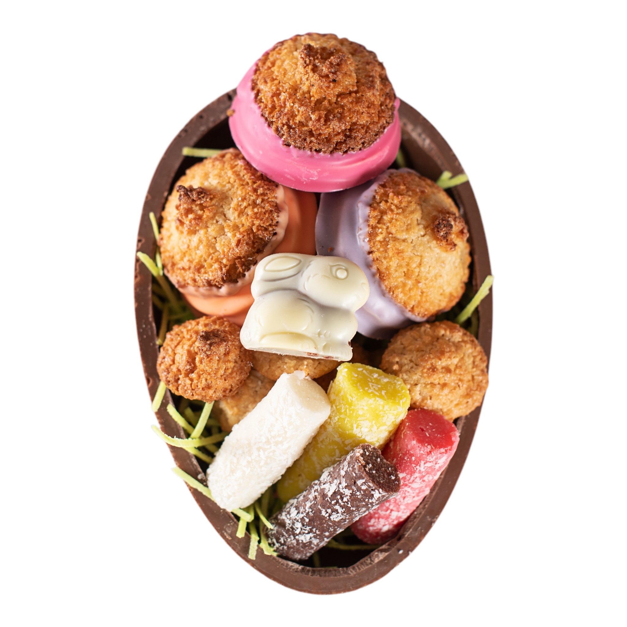 Schokoladen-Osterei gefüllt mit verschiedenen Sorten von Kokoskuppeln, Minibusserln, Kokosstangen und Schokohase auf Ostergras – ohne Alkohol